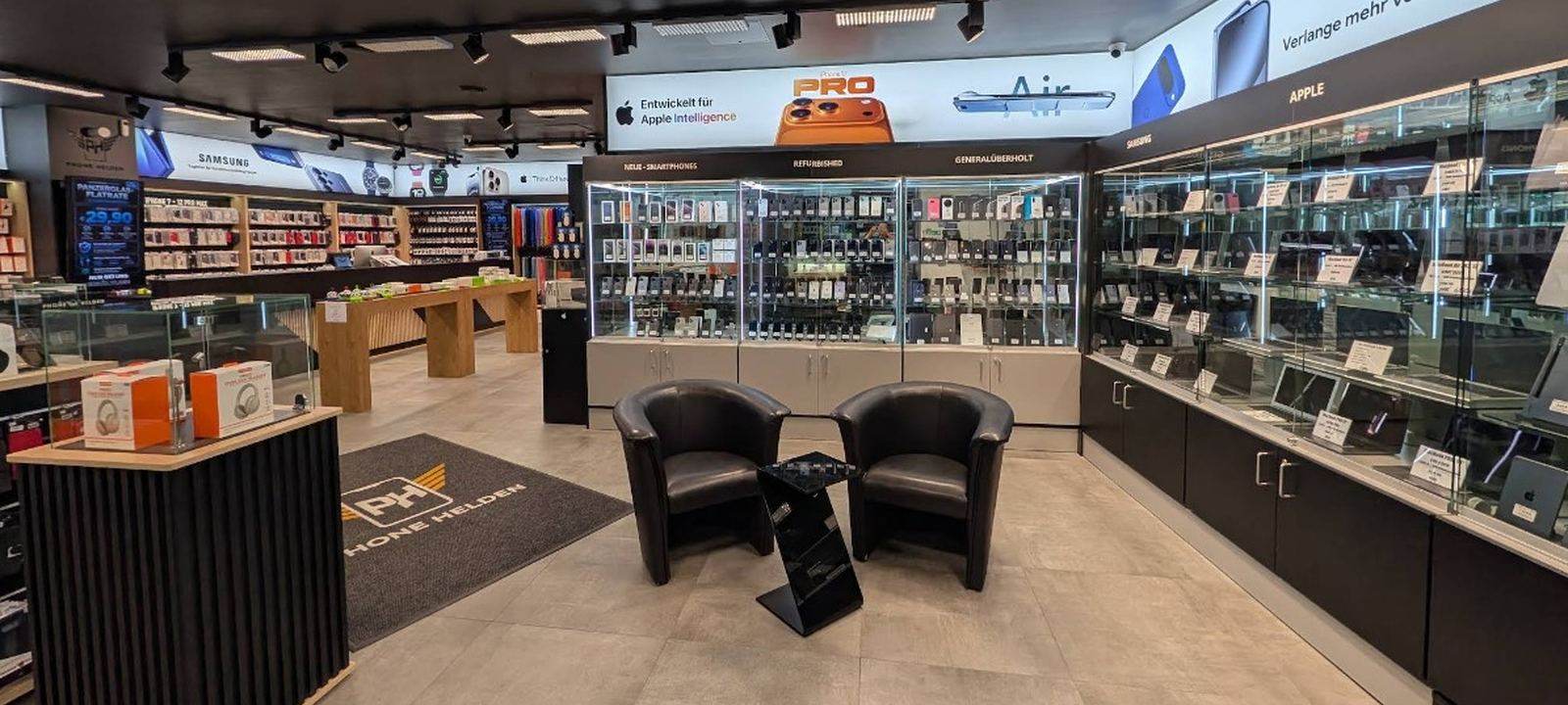 PhoneHelden Hamburg — Wartebereich mit Sitzecke und Vitrinen